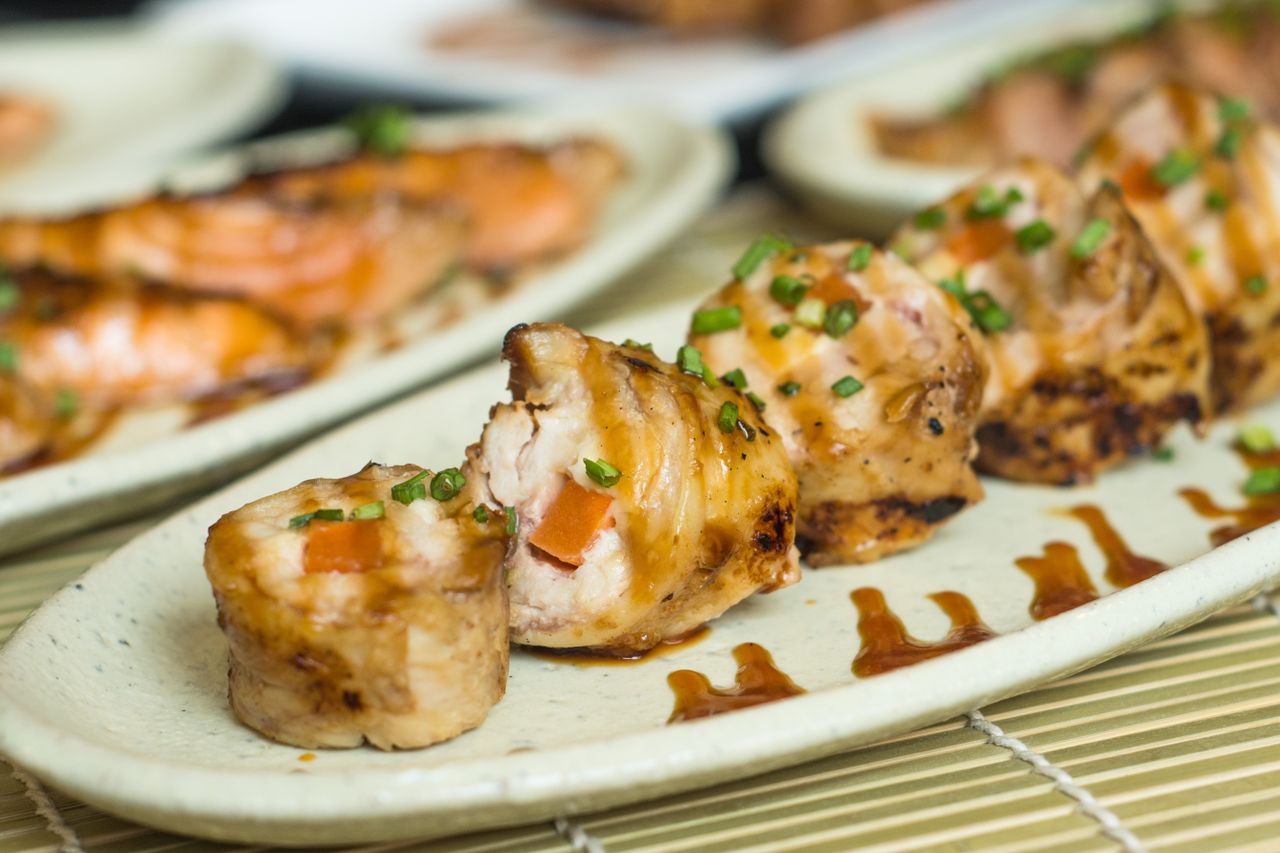 The Art of Drawing Readers In: Your attractive post title goes here Delicious grilled sushi rolls garnished with green onion and sauce on ceramic plate.